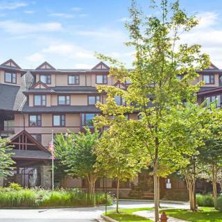 A hotel building surrounded by lush greenery and trees.