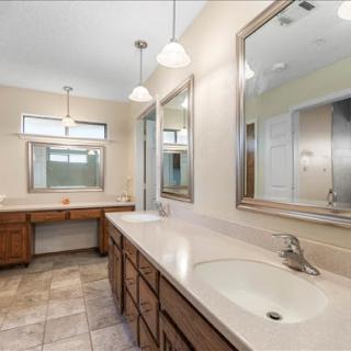 A spacious and modern bathroom featuring double vanities, ample lighting, and stylish mirrors.