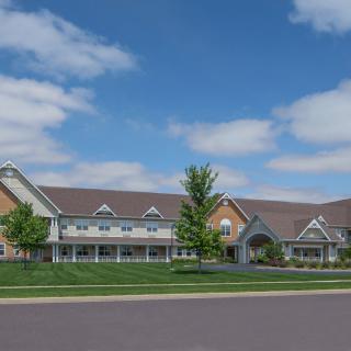 A suburban residential building with a well-maintained lawn under a partly cloudy sky.