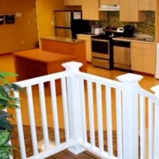 A modern kitchen with appliances and a small white fence partition.