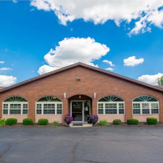 A charming brick building under a blue sky with fluffy clouds.