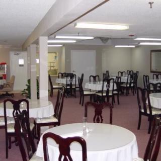 An empty dining room with round tables and chairs arranged neatly.