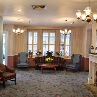 A cozy lobby with elegant chandeliers, comfortable seating, and large windows.