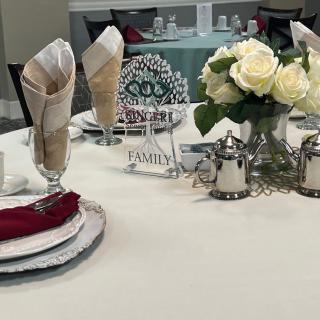 Elegant table setting with folded napkins and a floral centerpiece.