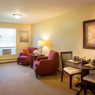 Cozy living room with comfortable chairs and a small dining area.