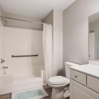 A modern and clean bathroom featuring a shower, toilet, and vanity.