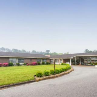 A single-story building with a curved driveway and well-maintained landscaping.