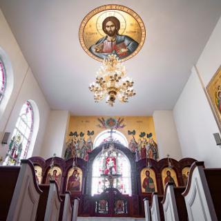 The beautiful interior of a church, showcasing religious icons and an ornate chandelier.