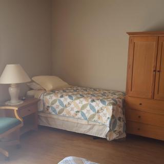 A cozy bedroom with a single bed, wardrobe, and nightstand.