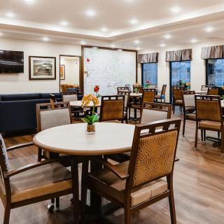 A well-lit dining area with neatly arranged tables and chairs.
