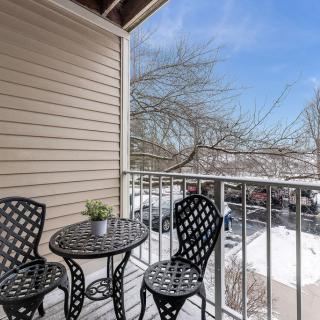 A cozy balcony with a small table and chairs, overlooking a snowy landscape.