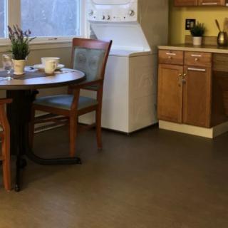 A cozy kitchen with a dining table and a washer, surrounded by wooden cupboards.