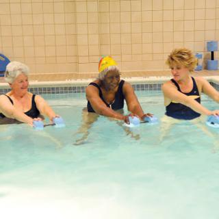 Seniors engaging in a water aerobics class, promoting fitness and wellness together.