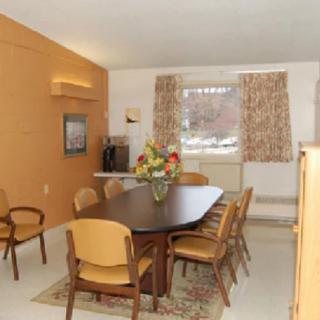 A vintage-style dining room with a wooden table, chairs, and floral centerpiece.