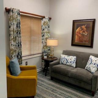 A cozy living room with a sofa, armchair, and decorative elements.