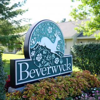 A decorative sign for Beverwyck surrounded by greenery and flowers.