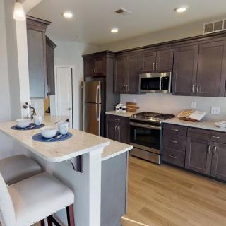 A modern kitchen with stainless steel appliances and a cozy breakfast bar.