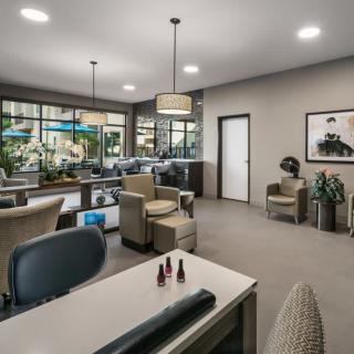 A modern nail salon interior with comfortable seating and contemporary decor.