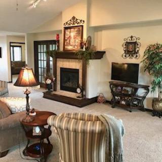 A cozy living room featuring a fireplace, sofa, television, and elegant decor.
