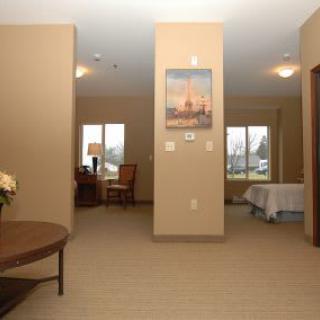 A view of a cozy interior space featuring a living room area with furniture and a connected bedroom.