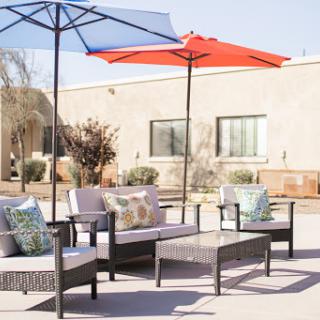 A cozy outdoor seating area featuring comfortable furniture and colorful umbrellas.