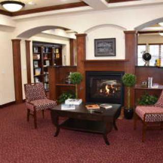 A cozy living room with a fireplace, bookshelves, and comfortable seating.