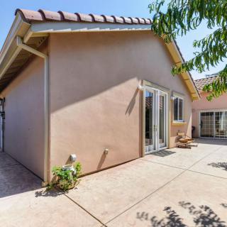 A sunny exterior view of a house with a spacious patio area.