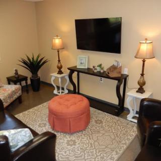 A cozy living room setup featuring a television, comfortable seating, decorative lamps, and a stylish coffee table.