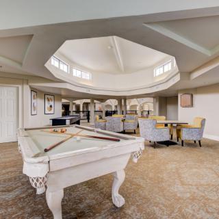 A spacious recreational room featuring a pool table and comfortable seating area.