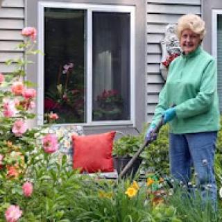 A woman tending to her beautiful garden filled with colorful flowers.