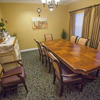 A well-decorated dining room with a large wooden table surrounded by chairs.