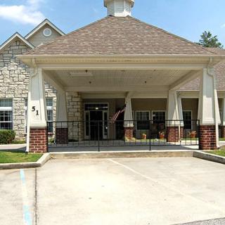 The image shows the entrance of a building with a stone facade and covered porch.