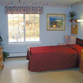 A cozy bedroom with a single bed, window, and decorative elements.