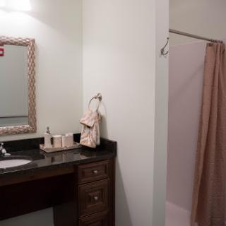 A simple and elegant bathroom setup featuring a mirror, sink, and shower area.