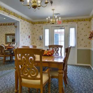 A traditional dining room with wooden furniture and a chandelier.