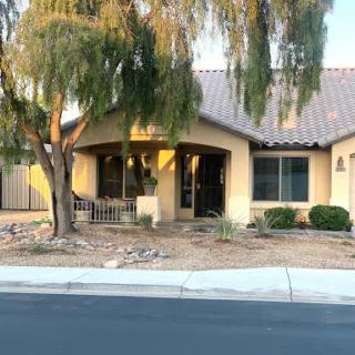 A charming residential house with a welcoming entrance and well-maintained landscaping.