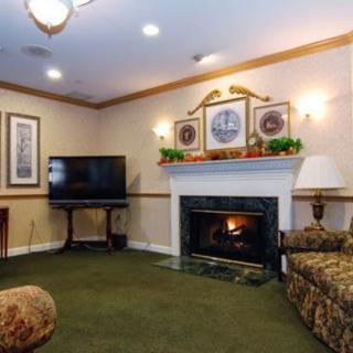 A cozy living room with a fireplace and a television, featuring comfortable seating and warm decor.