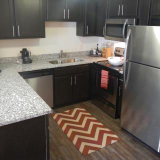 A modern kitchen with stainless steel appliances and dark cabinetry.