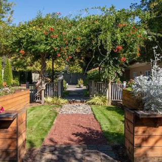 A beautifully landscaped garden with a brick pathway and lush greenery.