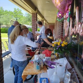 A community gathering with people preparing for a celebration outdoors.