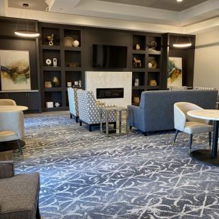 A modern lounge with comfortable seating and a fireplace.