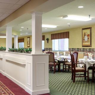 A warm and inviting dining area in a restaurant, featuring tables set for meals, decorative elements, and a cozy ambiance.