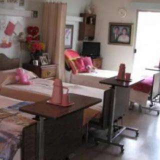 A hospital room with multiple beds and medical equipment.