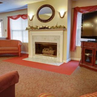 A cozy living room with a fireplace, sofa, and television.