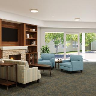 A modern and cozy living room with comfortable seating, a fireplace, and large windows overlooking a garden.