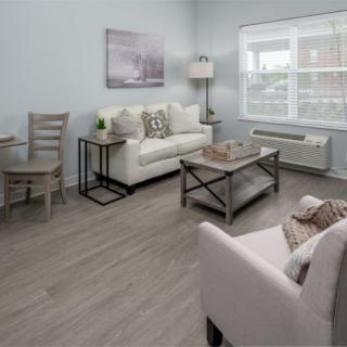 A modern, minimalist living room with a cozy sofa and armchair, complemented by a coffee table and stylish decor.