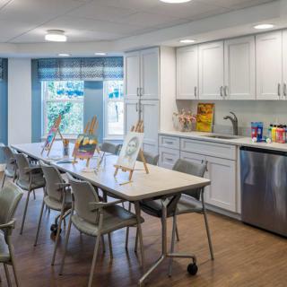 A well-lit kitchen area with art supplies set up on tables.
