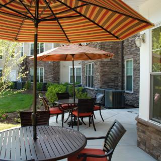 A cozy outdoor patio with tables and umbrellas for shade.