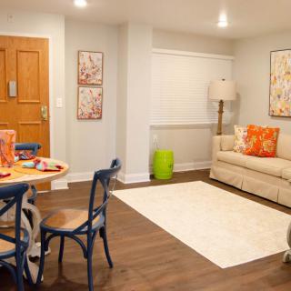A cozy living room with a small dining area, featuring warm colors and stylish decor.