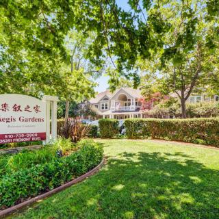 A well-maintained suburban property with lush landscaping and a welcoming entrance sign.